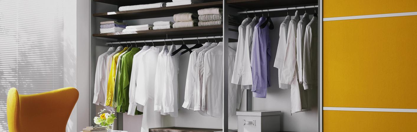 Kleiderschrank in orange mit Gleittüren geöffnet